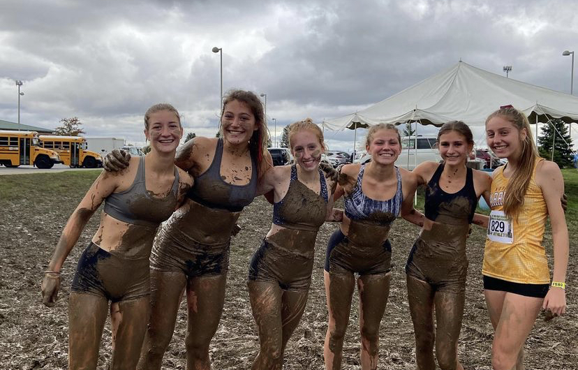 Six runners from the girls cross country celebrate in the mud after running at regionals. Runners from left to right: Hannah Hutto (12), Ashley Kisor (12), Paige Miracle (12), Amanda Cooper (11), Colleen Lynch (11), and Emily Widman (12) 