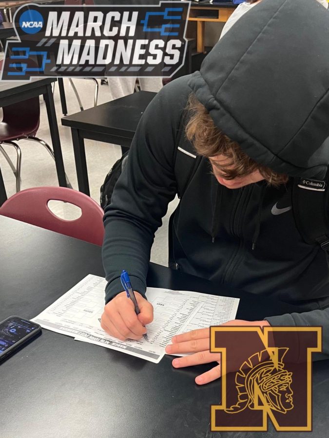 Trevor Newtz (12) fills out some March Madness brackets for his tournament.