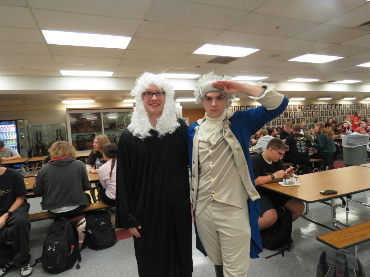 Two students pose for a photo wearing revolutionary attire for Rep Your Country spirit day. The student section will be dressed in this theme at the football game as well. 
