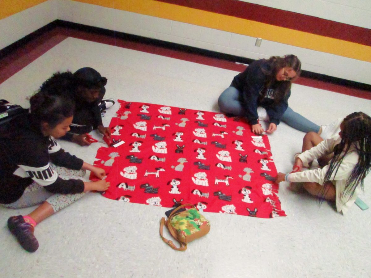 The volunteer club makes blankets to donate. They meet afterschool.