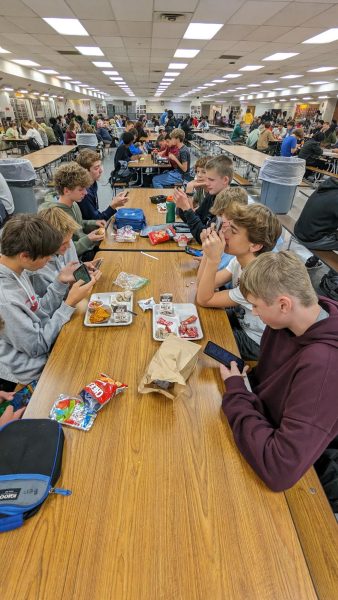 Students are on their phones at lunch. This is one of the few times a day they are allowed to use them.