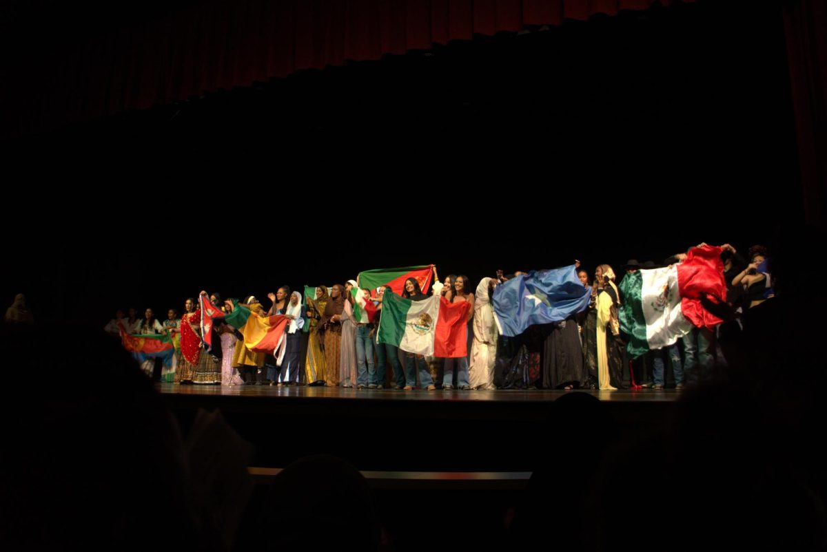 The cultural night performers take a bow after their first ever show. The all hold flags to represent their countries.