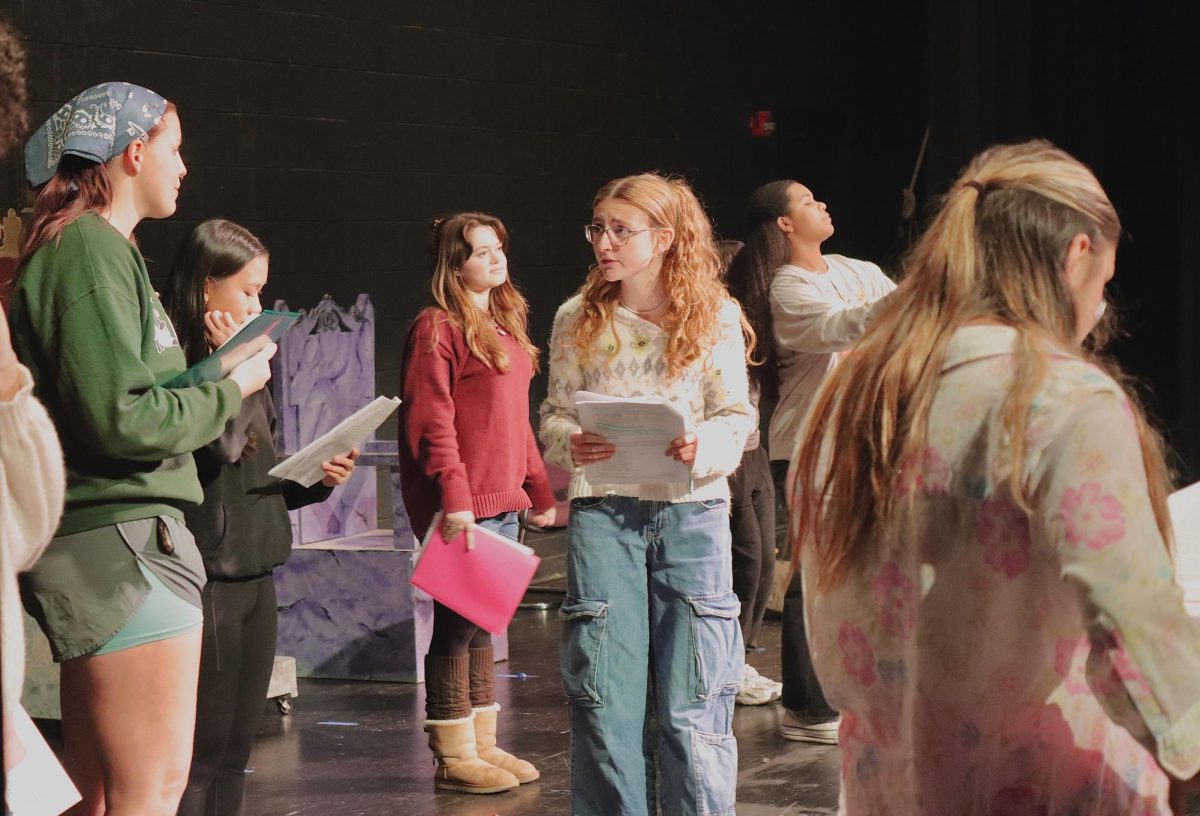 BTS: Sydney Caney Close up: Lead actor Sydney Caney ('27) practices her lines during a scene with  actors who are supposed to be flowers