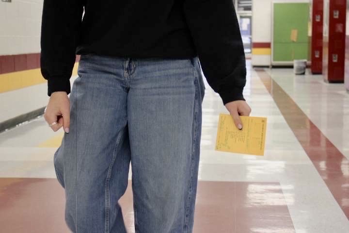 A student walking in the halls with a late slip in the middle of the day