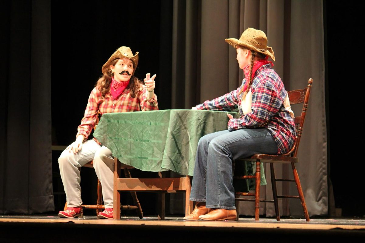 Ali Merrell ('26) and Emery Sullivan ('26) banter on stage during Long Tall Lester.